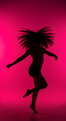 Silhouette Of A Woman Dancing Gracefully With Hair Flying In Pink Studio Light