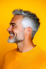 Obraz premium Concept art of style for aging men. Yellow solid background. A joyful male captured in a professional portrait. Trendy men's layered waves haircut - midlife white man with grey hair.