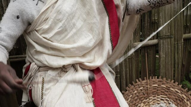 Detail of a woman in Ethiopia spinning cotton into thread.