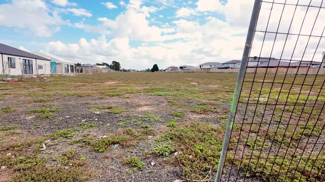 An empty residential lot in Werribee, Melbourne's growing outer suburb, cleared and vacant land of a future neighborhood surrounded by newly constructed modern homes in Australia