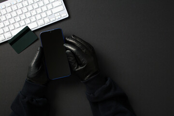 Online fraud and hacking: anonymous user with phone, keyboard, and credit card