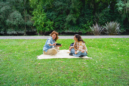 Cheerful friends sharing a selfie on the lawn - Powered by Adobe