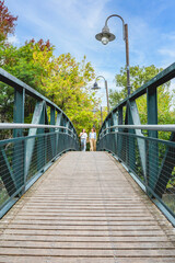 Vertical shot of women sharing laughter as they stroll over a beautiful bridge