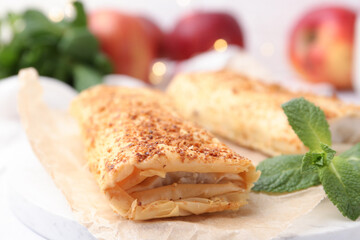 Tasty apple strudels and mint on table, closeup