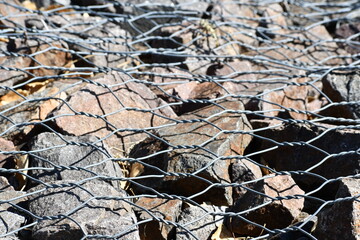 Metal fencing keeps rocks from falling on road. Keeps erosion at a minimum.