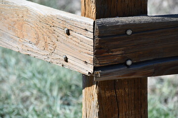 Wooden fence corner post, split beam at nail head.