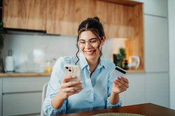 Young caucasian woman shop or pay online using credit card and cellphone
