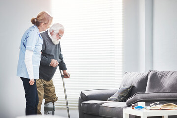 Physiotherapy nurse helping an injured senior man with a crutch and recovery in a retirement home....
