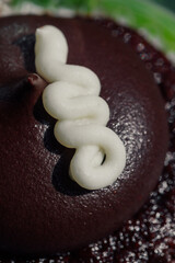 vanilla frosting squiggle on chocolate cupcake