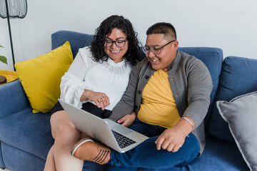 Latin lesbian couple working from home using laptop together in Mexico, young Hispanic homosexual people from lgbt community in home office in Latin America