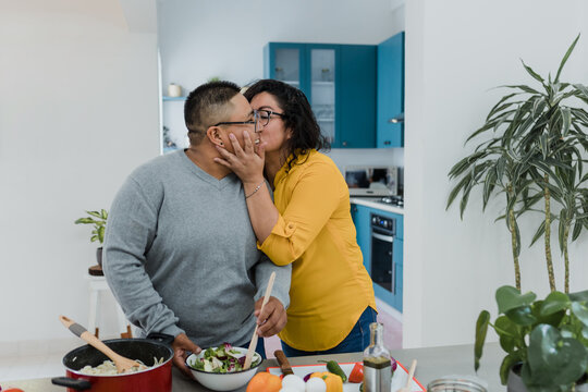 young Latin lesbian couple cooking dinner at home in Mexico, Hispanic homosexual people from lgbt community in Latin America preparing food in kitchen