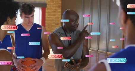 Male coach holding tablet and gesturing on basketball court, showing AR sports analytics data icons - Powered by Adobe