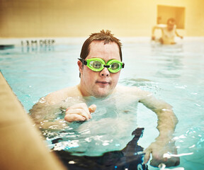 Down syndrome, disability and autism man in swimming pool for physical therapy, relax and healthy...