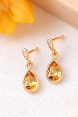 Elegant pear-shaped citrine drop earrings with tiny accent diamonds, set in gold