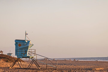 Lifeguard tower stands watch over serene beach at sunset