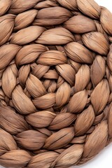 Circular, tightly woven brown natural fiber placemat  Detailed, concentric braid pattern