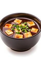 Dark-brown broth miso soup, filled with cubed tofu and garnished with finely chopped scallions