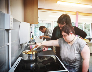 Family, down syndrome and cooking by mother and girl in a kitchen at home, bonding while learning...