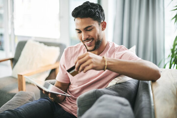 Credit card, online shopping and man on sofa on tablet for internet discount, purchase and payment...