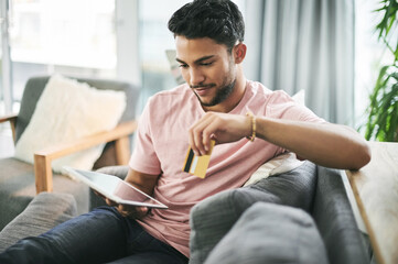 Credit card, home and man on sofa on tablet for online shopping, internet purchase and payment....