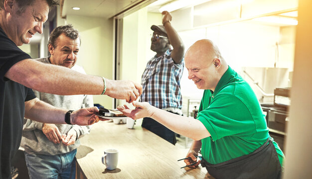 Community, volunteer and help with a down syndrome man in a kitchen of a home for learning, development and activism. Charity, relief and aid with a male working with a patient with a disability