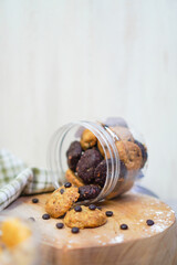 cookie jar open and lying on a wooden pedestal, surrounded by choco chips
