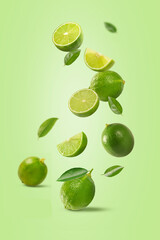 Fresh ripe lime with slices and leaves falling in the air on light green background.