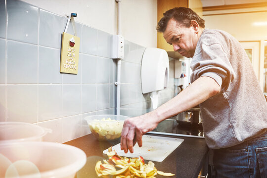 Food, disability and healthcare facility with an adult man cooking and prepare healthy meal. Mature male learning independence and development skills in control, safe environment for special needs