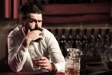 Whiskey glass held by bearded man. Guy drinking whiskey alone at bar. Whiskey pour in classic vintage glass. Whiskey tasting with retro style. Expensive whisky. Cognac or whisky. Alcoholic beverage.