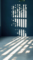 A blue wall with a window and a plant in front of it. The window is open, and the sunlight is shining through the window, creating a shadow on the wall