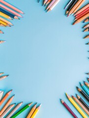 Fototapeta premium Colorful assortment of ened colored pencils arranged in a circular pattern on light blue background, creative art supplies for drawing and designing