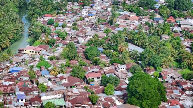 Aerial view of a typical working‑class residential community along the shoreline of Cagayan de Oro in Mindanao, Philippines, showcasing clustered homes and waterfront living.