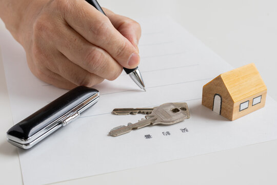 契約書にサインをする男性の手