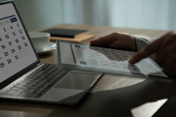 Event planner note on calendar businessman uses her smartphone and laptop to plan events, manage her schedule, and stay connected online