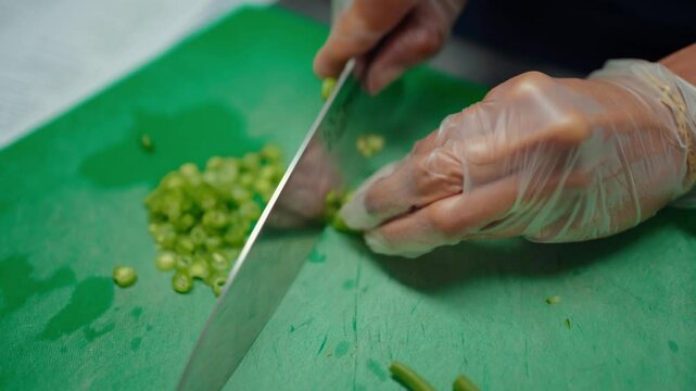 Closeup of Chef cutting fresh vegetables by hand during food preparation training session