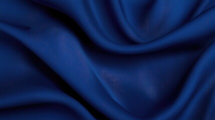Fototapeta premium Elegant dark blue silk fabric draped in soft waves, creating a luxurious textured background.