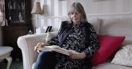 Relax, book and senior woman reading a fantasy novel while sitting on a sofa in her living room. Calm, peace and elderly lady in retirement enjoying a story while relaxing on the couch in her home.