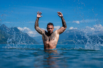 Sexy summer man. Muscular body. Hot summer. Man swimming in lake. Guy splash in water in summer...