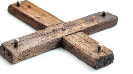 Fototapeta premium Wooden cross with small metal nails embedded along edges on white background.