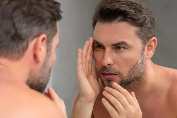 Obraz premium Caucasian beauty man use moisturizing face balm for healthy skin, male skincare concept. Male beauty and skin care portrait. Healthy clean face after shaving, facial treatment, skincare concept.