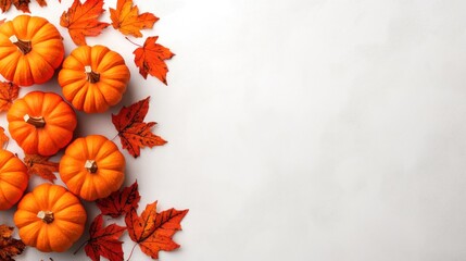 Fototapeta premium a cozy autumnal arrangement featuring vibrant pumpkins and fallen maple leaves on a smooth white surface evoking a sense of harvest season abundance and festive cheer