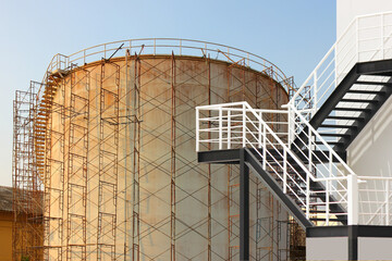 emergency steel stairs outside factory building in front of storage tank under renovate