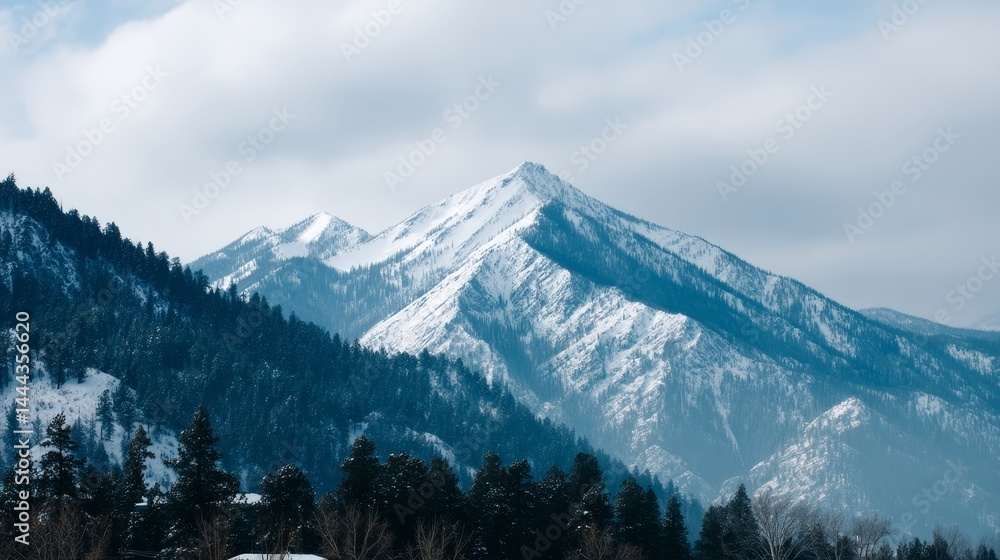 Aufkleber snow-capped mountain peak towers above the rugged terrain with a clear view of the surrounding range