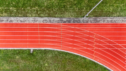 Running track aerial drone view background from above, athletic stadium with track lines bird’s...