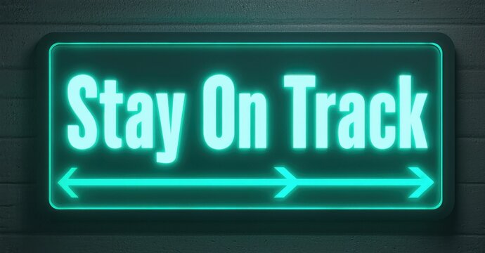 Bright neon sign displays Stay On Track with arrows pointing left, right. Dark textured background provides contrast.