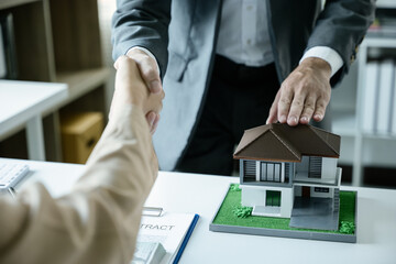 Close up of business's hands selling and signing agreement paperwork for loan financial to buying the house properties, real estate.
