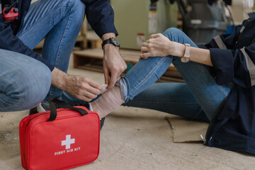 First aid support accident at work of worker at factory. Male worker has an accident on the floor in warehouse site.