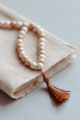 close-up of textured prayer mat and single string of prayer beads emphasizing minimalistic spirituality
