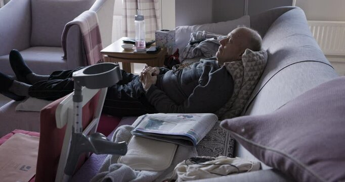 Retirement, rehabilitation and mature man sleeping on the couch for rest and recovery after surgery. Retire, senior male and sofa sleep or nap for surgical recovering process while resting