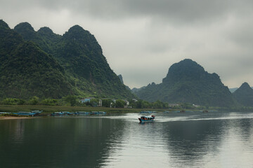 A boat taking tourists for a tour down the river of scenic valley of Quang Binh province in famous Phong Nha area of rural Vietnam